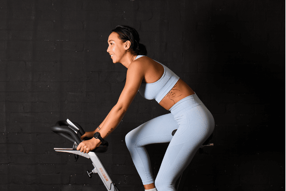 girl happily cycling at gym